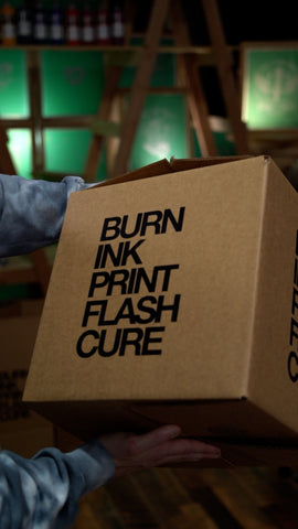 A man holds up a box with writing on it