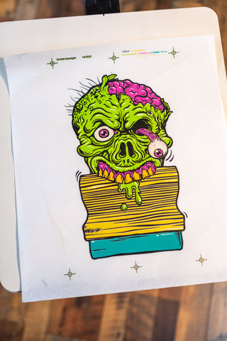 A final print of a zombie holding a squeegee in its teeth