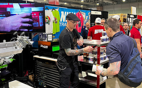 a man in a hat helps a customer at a trade show