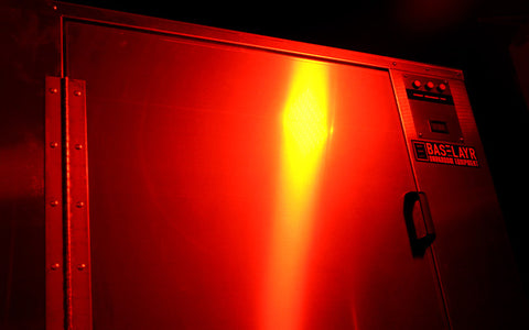 Un gabinete de secado se sienta en un cuarto oscuro con las bombillas seguras de luz amarilla