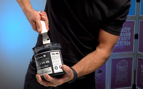 person mixing black fn-ink using a spatula