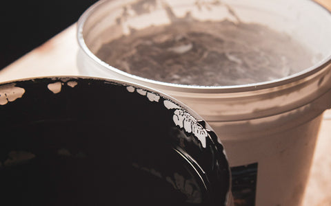 two buckets of water-based ink sit next to each other on a table