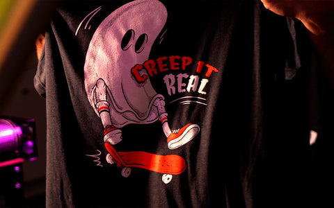 a print of a ghost doing a kick flip on a skateboard with the text saying creep it real