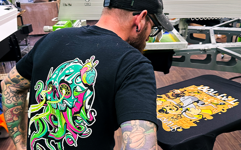 Andrew Boyd looks over a screen print on their ROQ Auto