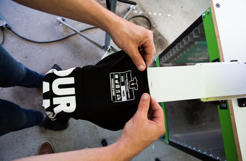 person printing a neck label on a press