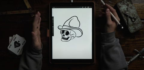 hands drawing a skull on an ipad