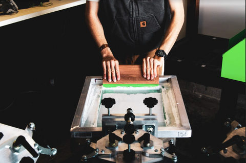 person pushing white ink on a screen