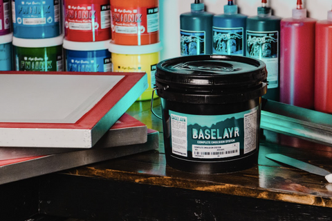 baselayr complete emulsion on a table next to a few screens with inks behind it