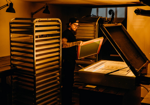 A man inspecting a screen in a darkroom 