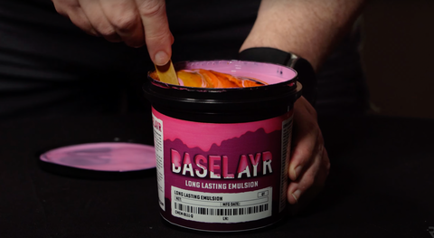 A hand mixing diazo into pink emulsion