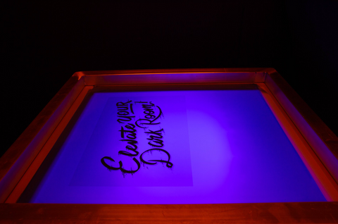 A screen reading "elevate your darkroom" on top of an LED exposure unit