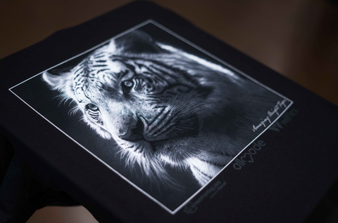 a white print of a tiger's head on a black shirt