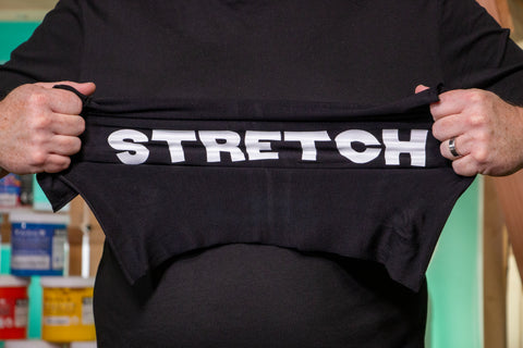 Hands stretch a black shirt reading "Stretch" in white letters