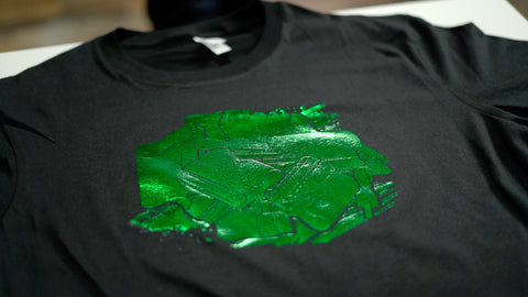 A green foil design on a black shirt