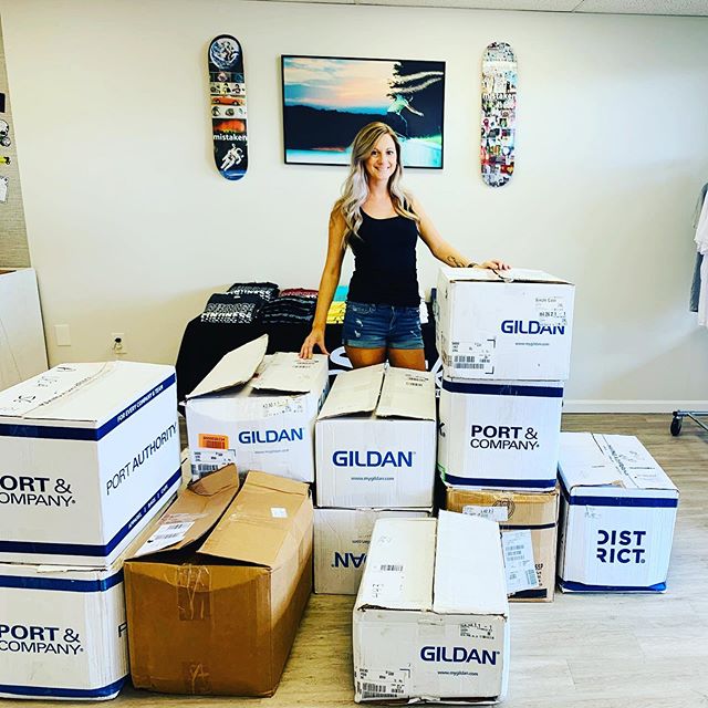 woman standing behind a ton of boxes