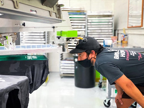 person inspecting a print on a roq press