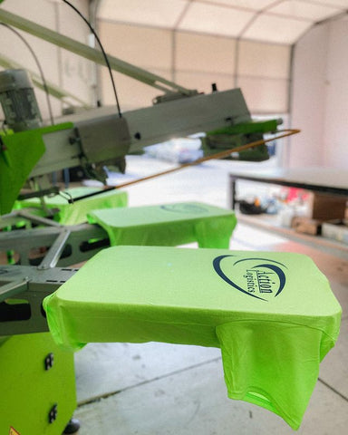 a neon green shirt with black text on it on a roq automatic press
