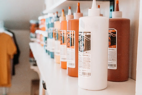 Bottles of pigment in the Fusion Mixing System sit on a shelf