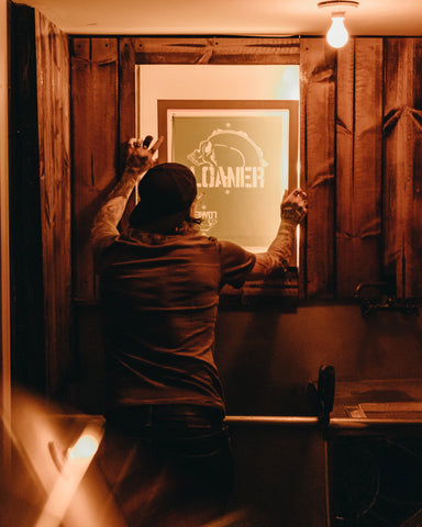 A man holds up an exposed screen to a light