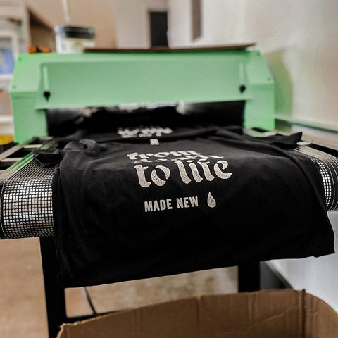 a black shirt coming out of the conveyor dryer