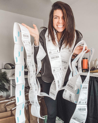 woman standing with a bunch of order stickers