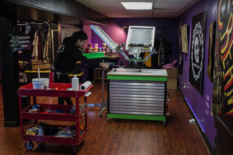 a basement print shop. printer is standing in front of their 150 press