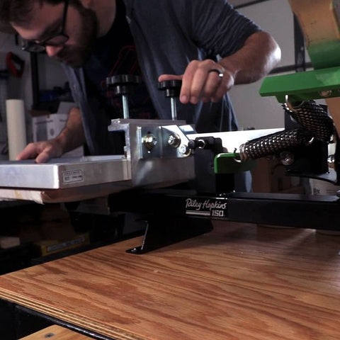 person registering a print on a riley 150 press