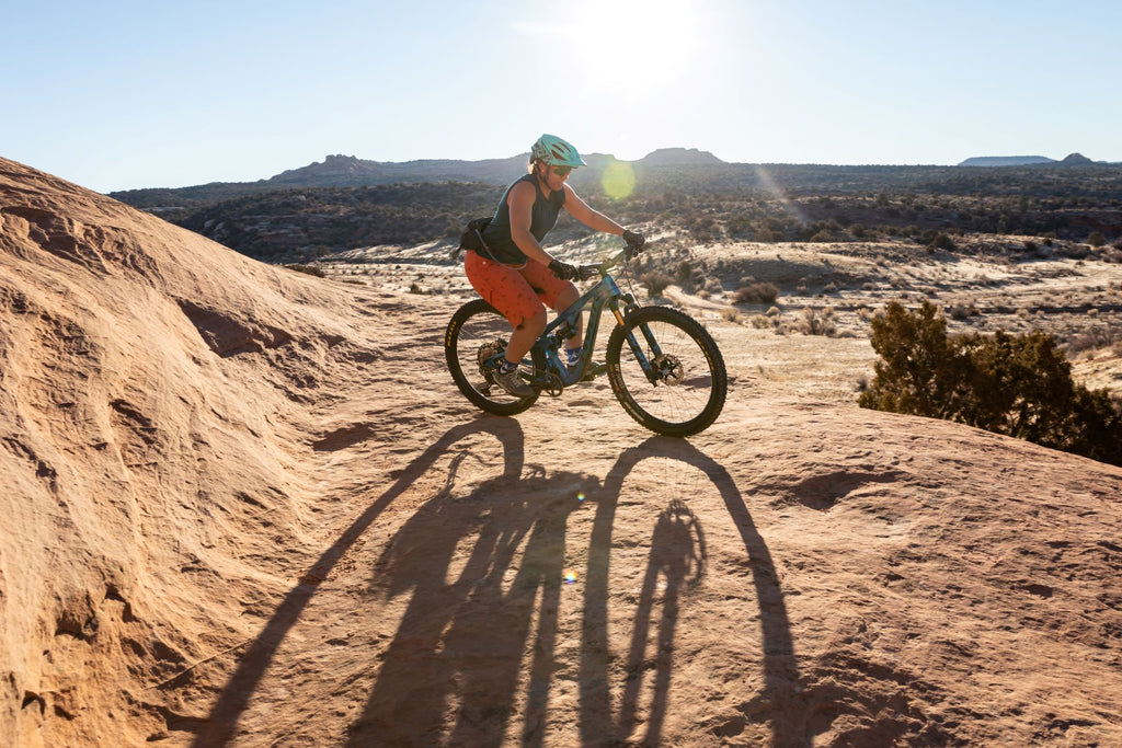 Woman riding her mountain bike over sandstone