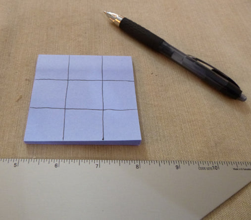 Tic-tac-toe pattern drawn on a Post-It note
