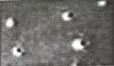 Closeup of a photo of a fireworks shell explosing showing the stars being thrown and the flame trailing behind