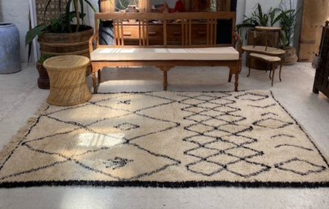 Image of cream and black vintage Moroccan rug strategically placed by a vintage day bed.