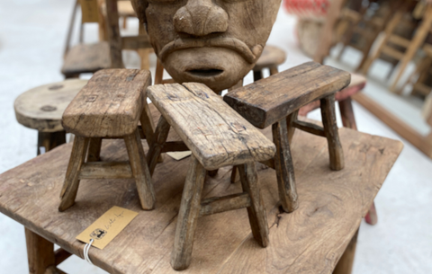 three rustic Asian furniture stools upon a table