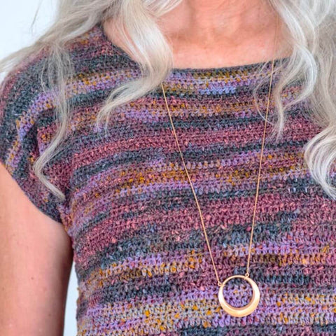 Crochet tee pattern in a variegated purple, blue and orang mix.