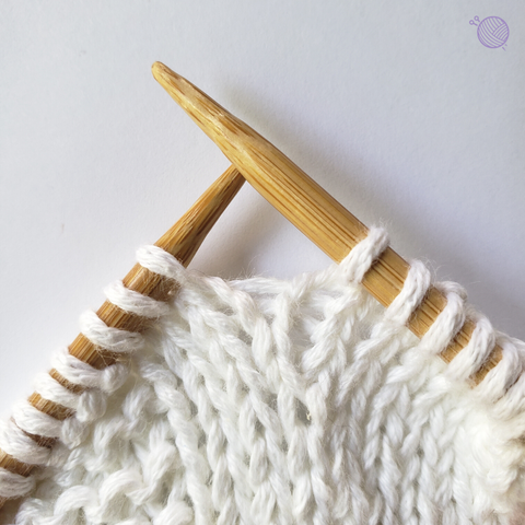 Bamboo knitting needles working with white yarn.