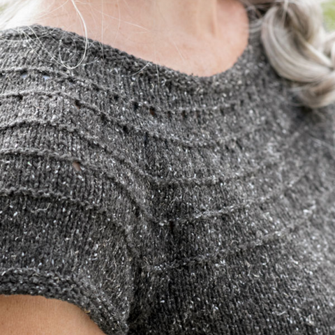 Close up of the yoke on a dark gray short-sleeved sweater.