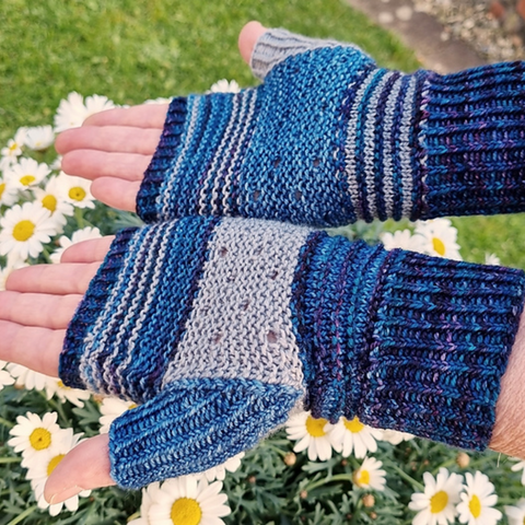 Pair of hands wearing fingerless mittens in shades of blue.