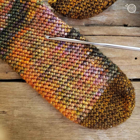 Top of crochet sock with obvious pooling from hand dyed yarn.