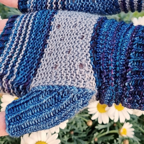 Pair of hands wearing fingerless mittens in shades of blue.
