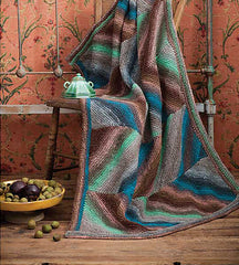 Knit blanket in blues and browns with a large-scale chevron pattern.