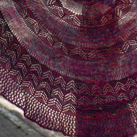 Light shining through the Chevron Delights Shawl, showing off the lace details and delicate mohair.