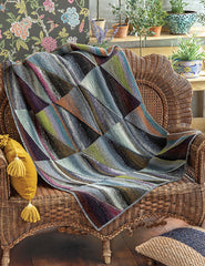 Knit blanket with triangles paired to create rectangles in neutral colors.