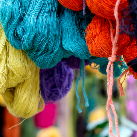 Brightly colored loops of cotton yarn hanging.