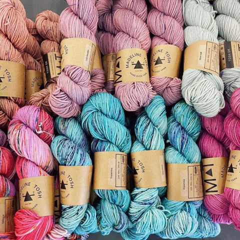 Skeins of hand dyed Madelinetosh yarns in pinks, blues and white.