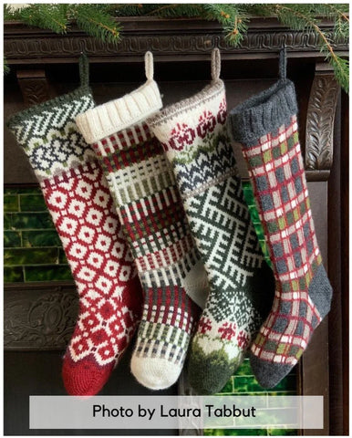 Image of four knit stockings hanging on a mantle. Photo by Laura Tabbut.