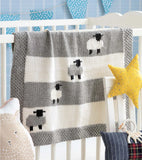 Knit blanket with gray and white sheep on a gray and white striped background.