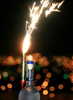 sparkling candle on a champagne bottle