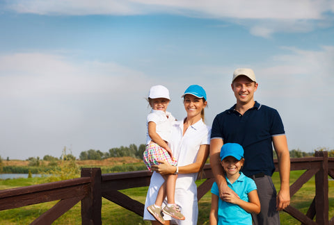 family wearing country club attire at a golf course on a sunny day