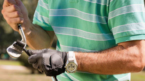 golfer using golf brush to clean a golf club