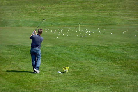 Male Golfer Chipping Golf Balls from a Distance