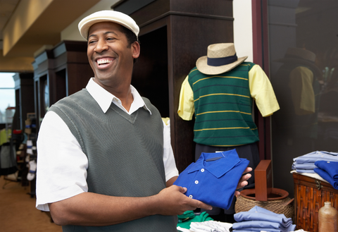 man in golf attire choosing golf shirt